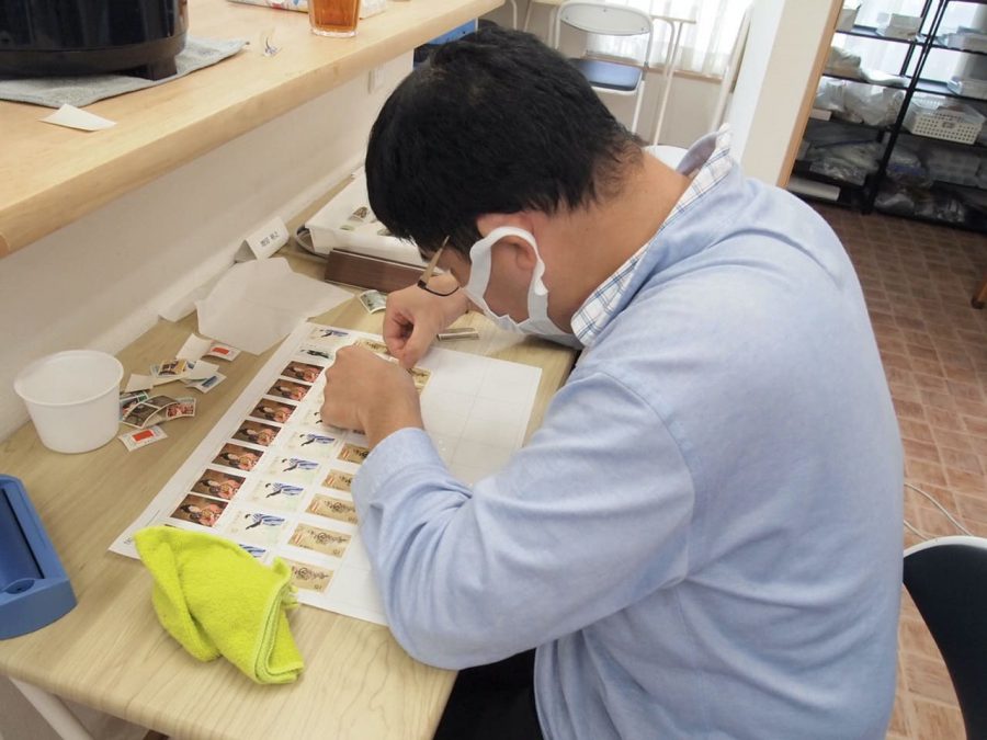 手貼りに集中する利用者の写真